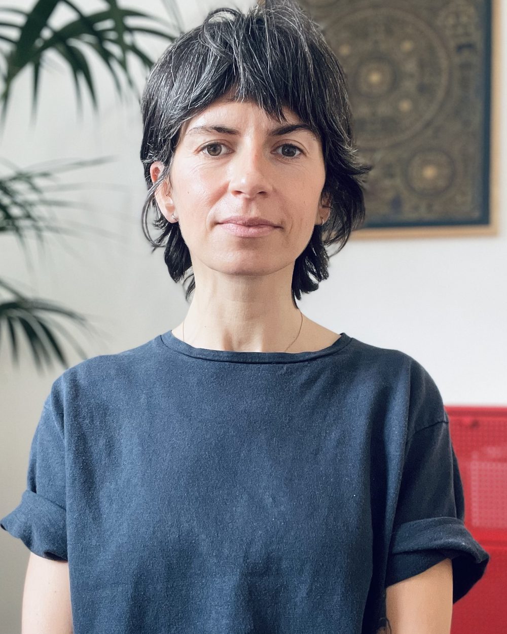 Portret Justyny Krupy w gabinecie, w tle roślina i obraz